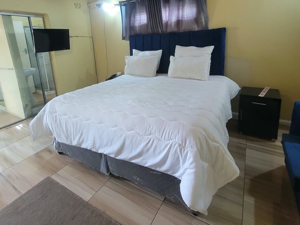 Executive Room with king bed, TV and en-suite at Afro Lodges & Motels, Borrowdale, Harare