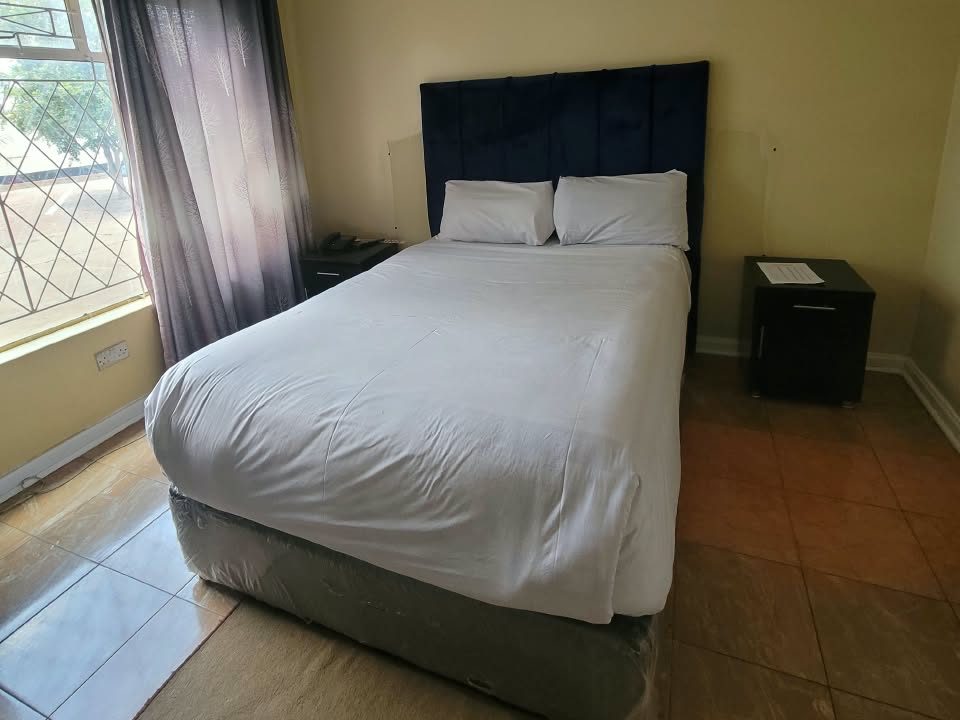 Standard Room with single bed and garden window at Afro Lodges & Motels, Borrowdale, Harare