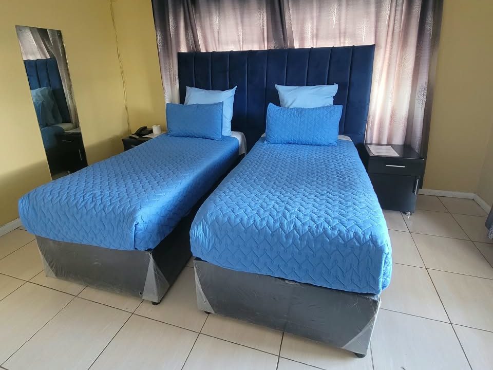 Standard twin room with blue bedding at Afro Lodges & Motels, Borrowdale, Harare