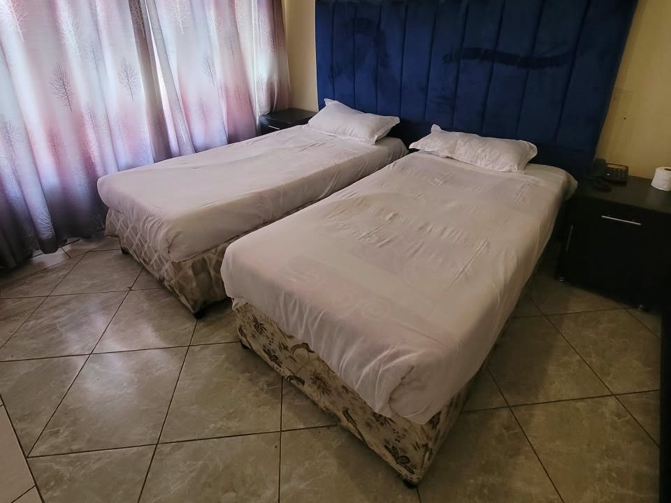 Standard twin room with white linen at Afro Lodges & Motels, Borrowdale, Harare